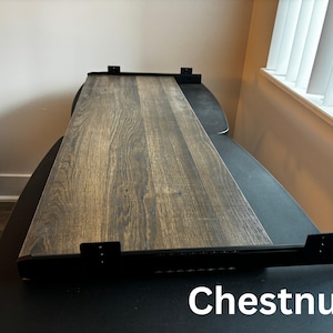 Puede incluir: Un estante rectangular con acabado de veta de madera en color casta&ntilde;o, con soportes met&aacute;licos negros fijados a los lados y la parte posterior para su montaje. La palabra Chestnut est&aacute; impresa en texto blanco en la esquina inferior derecha.