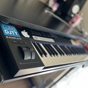 May include: A white ceramic mug with a black handle and the text "But First, Coffee" in a black, bold font. The mug is on a white surface. The mug is approximately 10 cm tall.