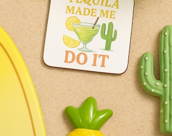 Può includere: Un sottobicchiere quadrato con la scritta "TEQUILA MADE ME DO IT" presenta un'illustrazione di margarita, un cactus e fette di limone. Sono visibili anche un ananas giallo e un cactus verde.