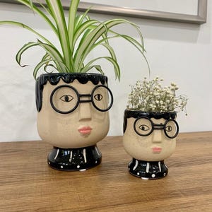 May include: A set of three ceramic mugs with a speckled, matte finish. The mugs are in shades of cream, light gray, and dark gray. Each mug has a simple, minimalist design, perfect for coffee or tea.