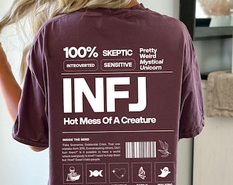 May include: A maroon t-shirt with white text that reads "100% Skeptic Introverted Sensitive Pretty Weird Mystical Unicorn INFJ Hot Mess Of A Creature". The shirt also has a graphic with a barcode and a list of personality traits, including "Socially Selective", "Fantasy Lover", "Intuitive Insightful", "Easily Hurt", and "Walking Paradox".