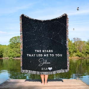 May include: A black woven blanket with a starry night design and the text "THE STARS THAT LED ME TO YOU" with the name "Julian" and date "10.3.24". The blanket has a fringed edge with colorful threads.