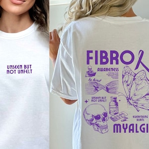 May include: White t-shirt with purple text that reads "Fibromyalgia Awareness" and includes a butterfly, skull, and pills. The text also says "Unseen but not unfelt" and "Everything hurts Myalgia".