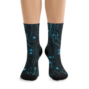 May include: A pair of black socks with a blue circuit board design. The socks feature a repeating pattern of lines and glowing blue dots, resembling an electronic circuit. The socks are knee-high and made of a soft material.