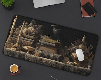 Puede incluir: Alfombrilla de ratón rectangular con un diseño oscuro de inspiración gótica. La imagen representa un cuervo posado sobre una pila de libros antiguos, con velas, flores y una urna decorativa. La paleta de colores incluye oro, marrón y negro.