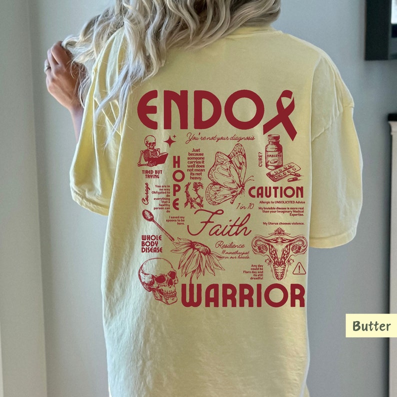 K&ouml;nnte beinhalten: Gelbes T-Shirt mit einem roten Grafikdesign, das "ENDO" sagt und verschiedene Illustrationen im Zusammenhang mit Endometriose enth&auml;lt, wie einen Schmetterling, einen Sch&auml;del, eine Geb&auml;rmutter und einen L&ouml;ffel. Der Text "You're not your diagnosis" ist ebenfalls im Design enthalten.