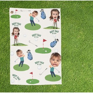 May include: Golf towel with a repeating pattern of cartoon figures playing golf, golf bags, golf balls, and flags on green patches. The text "BEST DAD BY PAR" is repeated throughout the design. The towel has a loop for hanging.