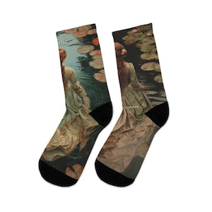 May include: A pair of socks featuring a vintage painting of a woman in a flowing dress standing in a pond with lily pads. The socks have black toes and heels, and the text "elia" and "tabter" are visible.