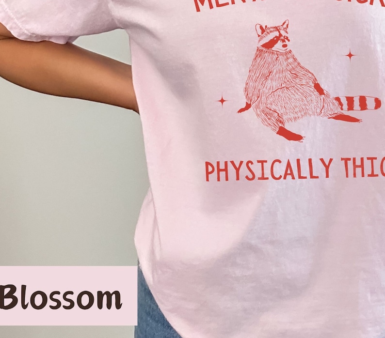 May include: Pink t-shirt with a red raccoon illustration and the text "Mentally a Snack, Physically Thick".