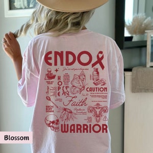 K&ouml;nnte beinhalten: Pinkes T-Shirt mit einem roten grafischen Design, das "ENDO" sagt und ein Schmetterling, ein Sch&auml;del, eine Geb&auml;rmutter und andere Illustrationen enth&auml;lt. Der Text enth&auml;lt auch die W&ouml;rter "HOPE", "Faith", "Warrior" und "You're not your diagnosis".
