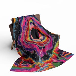 Puede incluir: Una manta con un dise&ntilde;o abstracto y vibrante que presenta patrones de remolinos en rosa intenso, naranja brillante, amarillo, azul verdoso y morado oscuro sobre un fondo negro. La est&eacute;tica fluida y jaspeada crea un efecto visual din&aacute;mico.