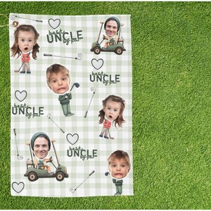 May include: Golf towel with a green and white checkered pattern. The towel features cartoon images of people and golf clubs, with the text "best uncle by par" and heart shapes. A gold grommet is at the top.