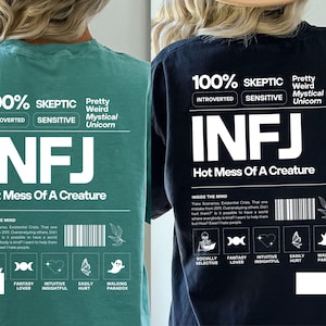 May include: A black and a teal green t-shirt with a white graphic print that says "100% Skeptic" and "INFJ Hot Mess Of A Creature". The graphic also includes a list of personality traits, such as "Introverted", "Sensitive", "Fantasy Lover", and "Intuitive Insightful".