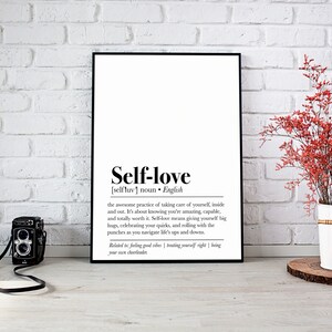 "Self-Love" defined in a chic print, complemented by a vibrant red floral arrangement and a vintage camera, blending inspiration with a touch of nostalgia.