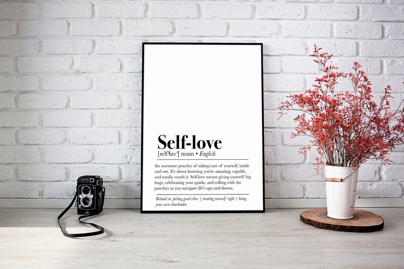 "Self-Love" defined in a chic print, complemented by a vibrant red floral arrangement and a vintage camera, blending inspiration with a touch of nostalgia.