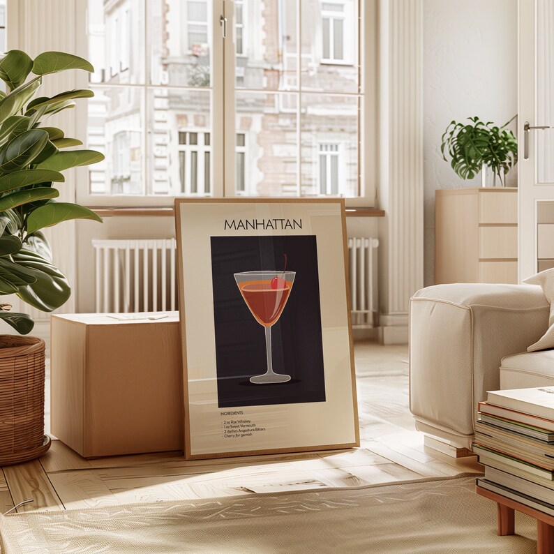 A framed "Manhattan" cocktail print propped up in a bright living room with modern furnishings and a large window, bringing a touch of elegance and charm to the setting.