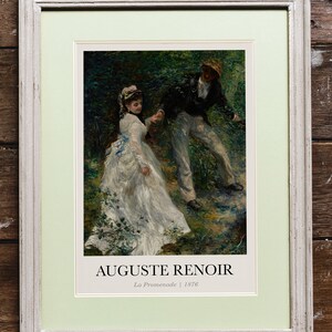 May include: A framed print of a painting by Auguste Renoir titled "La Promenade" from 1876. The painting depicts a couple walking through a wooded area. The woman is wearing a white dress and the man is wearing a dark jacket and light pants.