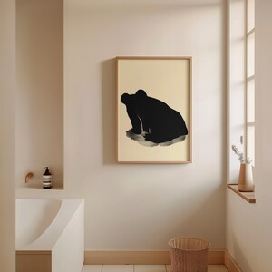 Minimalist bathroom with a single Matsumoto Hoji Frog Print on the wall, capturing the serene silhouette of a frog in deep contemplation against a light beige background, enhancing the tranquil atmosphere
