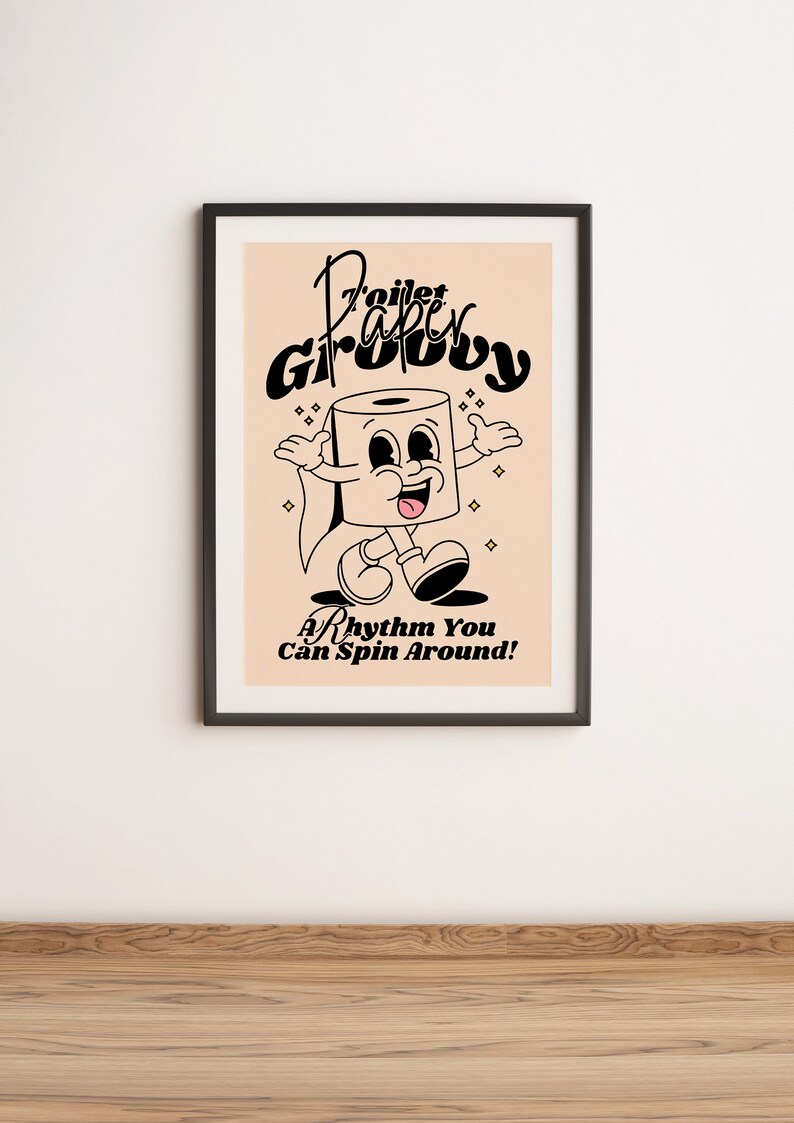 Op de afbeelding: Een zwart ingelijste poster met een licht perzikkleurige achtergrond. De poster toont een cartoon toiletpapierrol met een glimlachend gezicht en de tekst "Toilet Paper Groovy" in een retro-lettertype. De tekst "A Rhythm You Can Spin Around!" staat onder de cartoon.