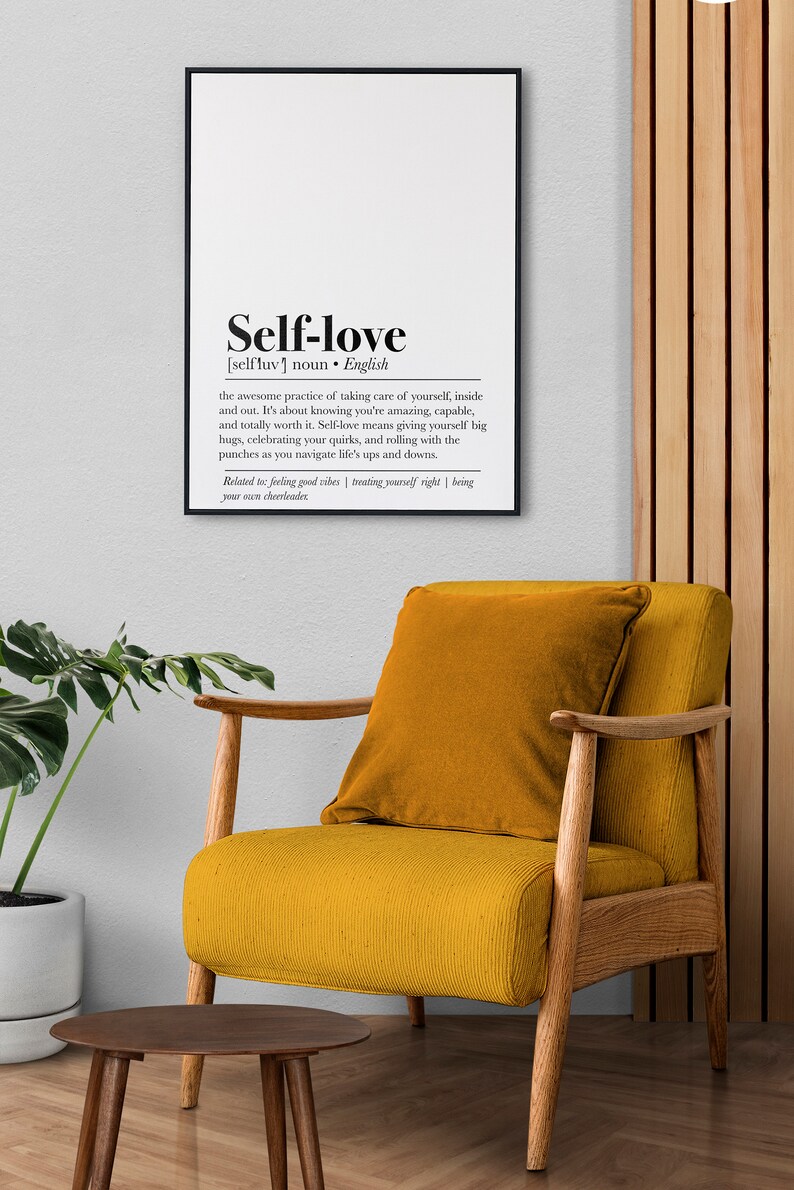 A print highlighting the definition of self-love in bold typography, framed and hung above a comfortable chair, evoking a sense of personal care and positivity.