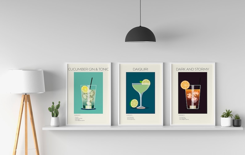 Three cocktail prints (Cucumber Gin & Tonic, Daiquiri, Dark and Stormy) displayed on a white shelf with minimalist décor, enhancing the stylish look of the space.