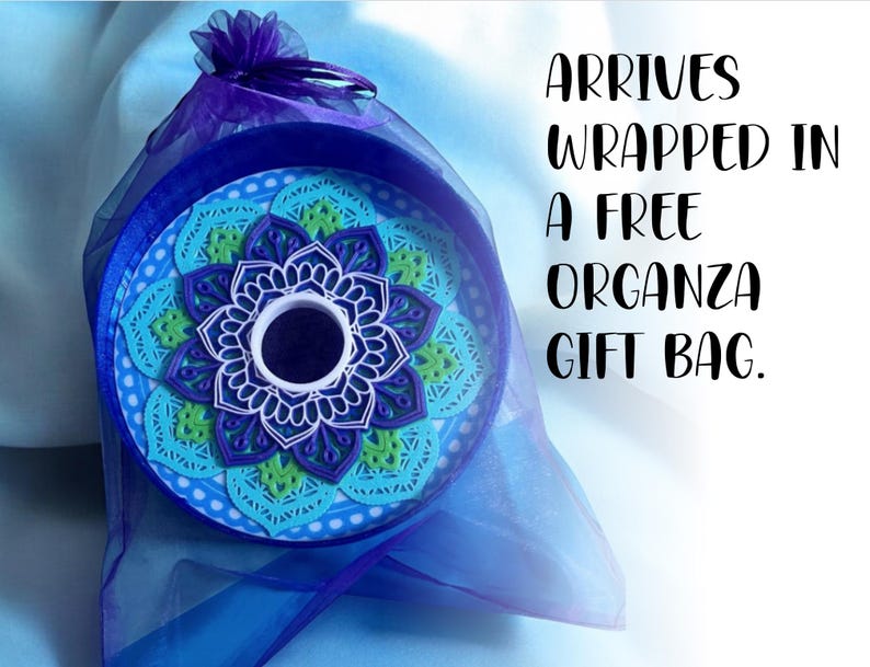 May include: A blue and green mandala design in a round frame, wrapped in a blue organza gift bag. Arrives wrapped in a free organza gift bag.