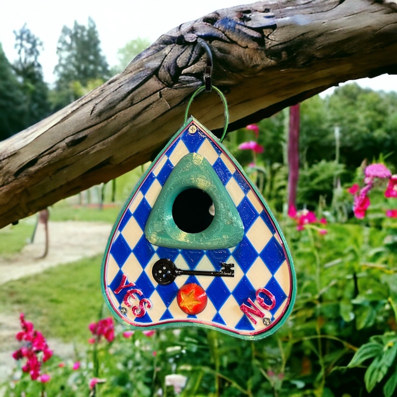 May include: A blue and white birdhouse shaped like a triangle with a green birdhouse opening and a keyhole. The birdhouse has the words "YES" and "NO" written on it.