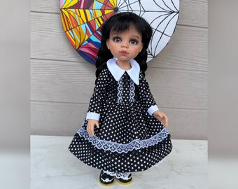 May include: A doll in a black dress with white star patterns and white lace trim. The doll has black pigtails and black shoes with yellow soles. The doll is positioned in front of a colourful background.