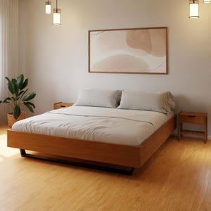 Peut inclure: Un cadre de lit en bois avec une finition brun clair et un matelas blanc. Le lit est dans une chambre avec un sol en bois brun clair et un tableau sur le mur.