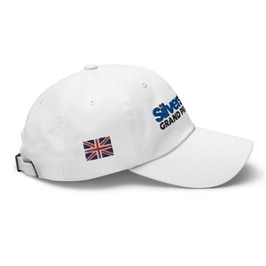 May include: White baseball cap with a blue and black embroidered logo that says "Silverstone Grand Prix" and a small embroidered Union Jack flag.