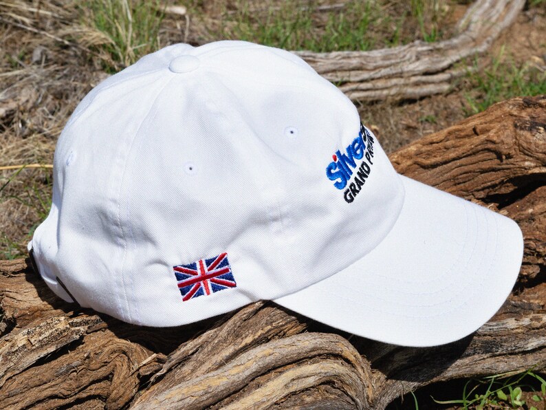 May include: White baseball cap with a blue and white embroidered logo that says "Silverstone Grand Prix" and a small embroidered Union Jack flag.