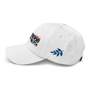 May include: White baseball cap with an embroidered logo that says "British Stone" and a blue leaf on the back.