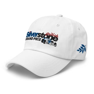 May include: White baseball cap with an embroidered logo that says "Silverstone British Grand Prix" with a small race car image. The cap has a blue and white leaf design on the side.