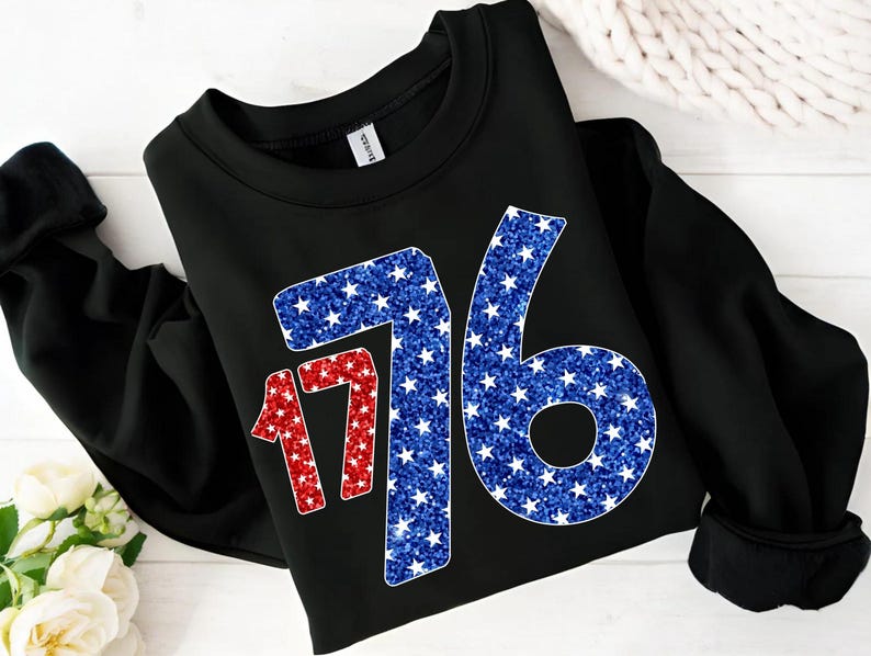 May include: Black sweatshirt with a red and blue glitter design of the number 1776. The numbers are made up of white stars on a red and blue background.