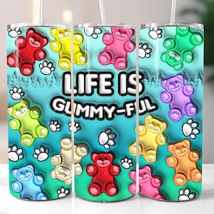 May include: Three stainless steel tumblers with a turquoise blue background and colorful gummy bear designs. The tumblers have the text "Life is Gummy-Ful" printed on them.