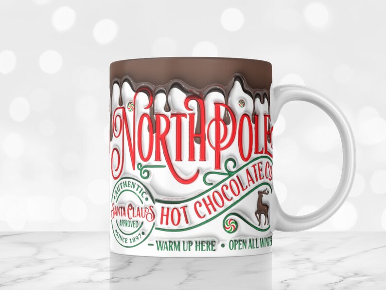 May include: White ceramic mug with a brown chocolate-like glaze dripping down the side. The mug features the text "North Pole Hot Chocolate Co." with a reindeer illustration and the words "Authentic Santa Claus Approved Since 1897" in a circle. The text "Warm Up Here - Open All Winter" is printed below the main text.
