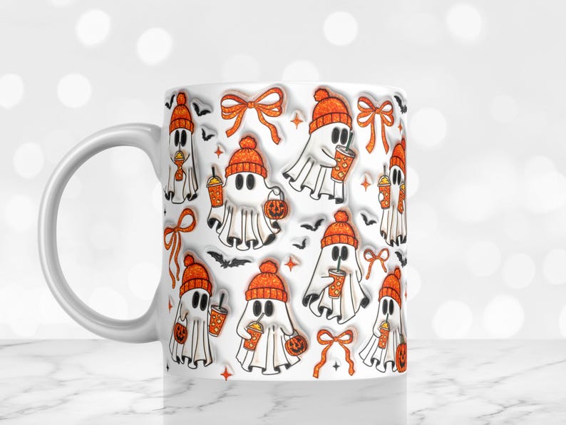 May include: White ceramic mug with a repeating pattern of cartoon ghosts wearing orange beanies, holding pumpkin-shaped lanterns and iced coffee. The design includes orange bows and black bats, perfect for Halloween.