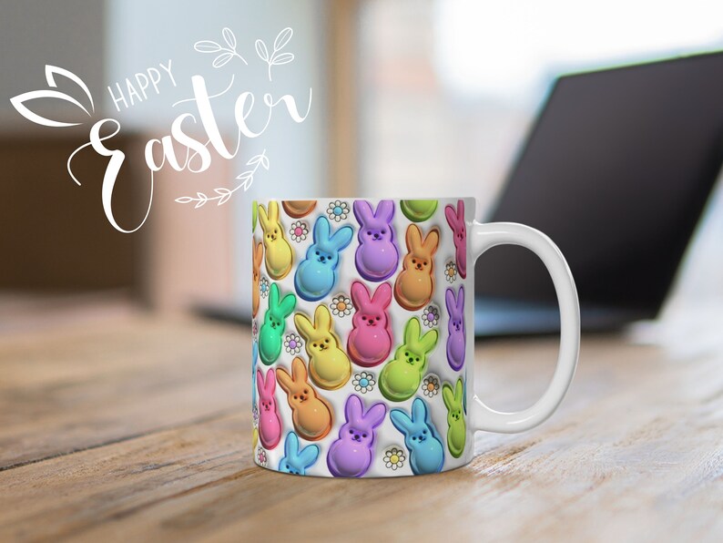 May include: White ceramic mug with a colorful pattern of pastel-colored bunny-shaped candies. The mug has a handle and says "Happy Easter" in white lettering.