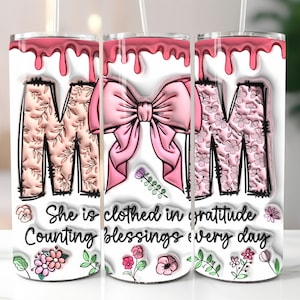 May include: Three pink and white patterned stainless steel tumblers with a pink bow and the text "She is clothed in gratitude Counting blessings every day".