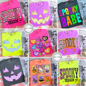 May include: A collection of Halloween-themed t-shirts in various colors, including pink, black, and orange. Each shirt features unique designs such as jack-o'-lantern faces, the phrase "Spooky Season," and candy heart graphics. The shirts are displayed on a white background.