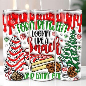 May include: A set of three white insulated tumblers with a Christmas theme. Each tumbler features a design with red dripping accents, snowflakes, and the text "Torn Between Lookin' Like a Snack and Eatin' One."