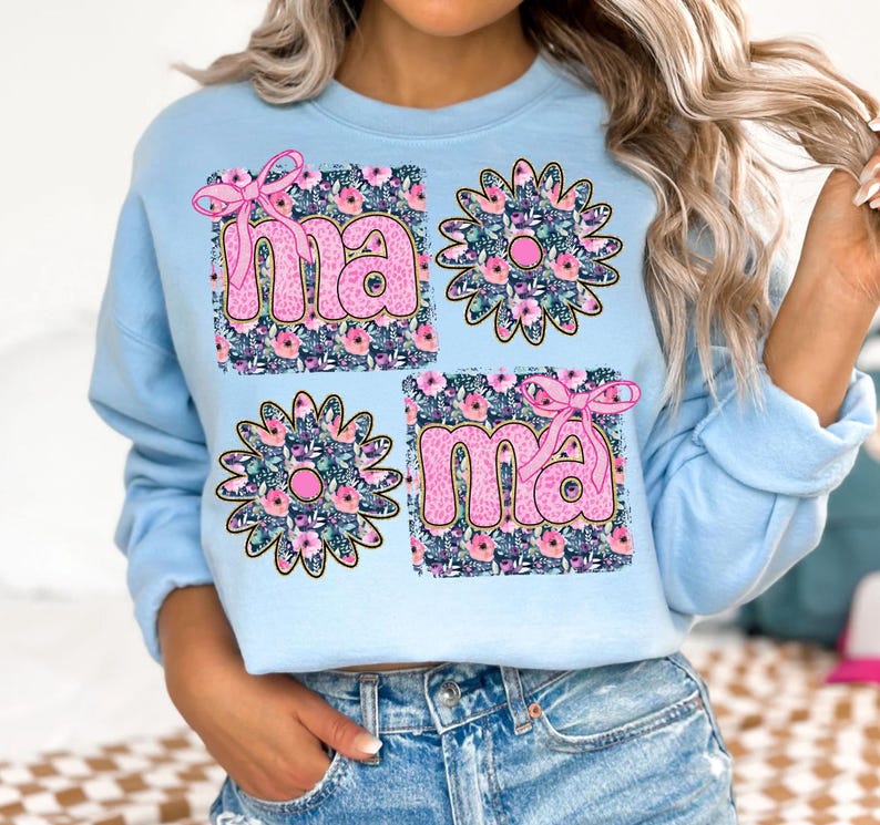 May include: Light blue sweatshirt with a floral design and the word "mama" in pink letters.