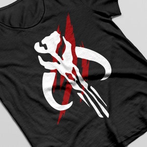 May include: Black t-shirt featuring a white and red graphic design. The design is a stylized skull with curved horns and red vertical streaks. The shirt is made of a soft, dark fabric.