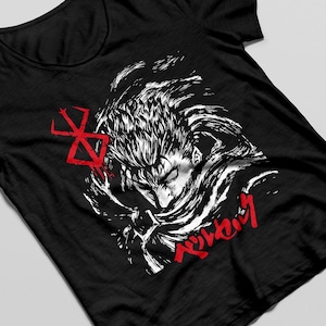 以下が含まれることがあります： 黒いTシャツに、アニメ「ベルセルク」のキャラクターの白いグラフィックがプリントされています。キャラクターはとがった髪をしていて、マントを着ています。キャラクターの下に赤い文字で「ベルセルク」と書かれています。