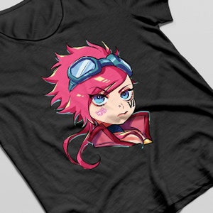 May include: Black t-shirt featuring a cartoon illustration of a character with pink hair, blue eyes, and goggles. The character has a determined expression and the number "VI" is printed on the cheek. The shirt is made of a soft material.