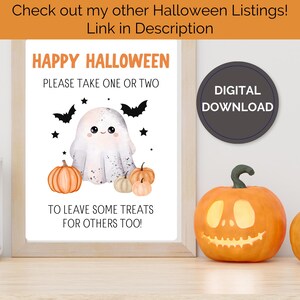 May include: A framed Halloween print featuring a friendly ghost, pumpkins, bats, and stars. The text says "Happy Halloween, Please Take One or Two, To Leave Some Treats For Others Too!" A digital download graphic is on the right.