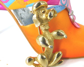 Classic French poodle small gold brooch. Gold with textured body by Sarah Coventry. Latch pin back. Comes packaged as a gift