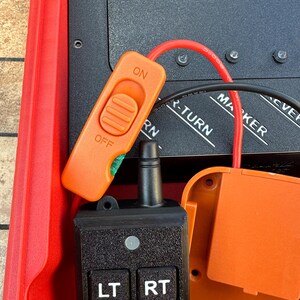 May include: An orange switch labeled "ON" and "OFF" is connected to a black control panel with buttons labeled "LT", "RT", "MK", and "RV". A red wire and black cable are also connected to the panel.