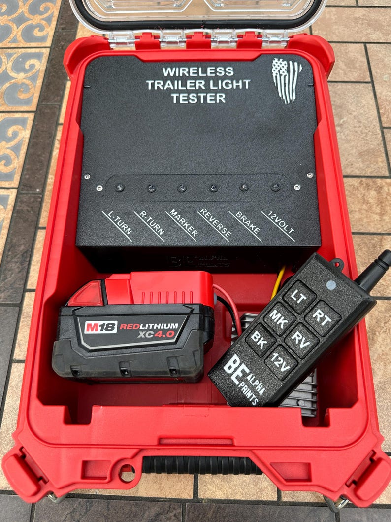 Pu&ograve; includere: Un kit tester per luci per rimorchi wireless rosso. Il kit include un pannello di controllo nero con pulsanti etichettati e un telecomando. Il kit include anche una batteria rossa M18 REDLITHIUM XC4.0.