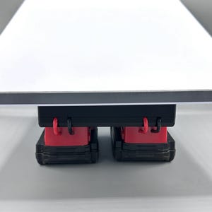 Op de afbeelding: Een zwarte speelgoedtruck met rode accenten en een aanhanger met een vlakke laadbak. De truck is gedetailleerd en gemaakt van plastic.